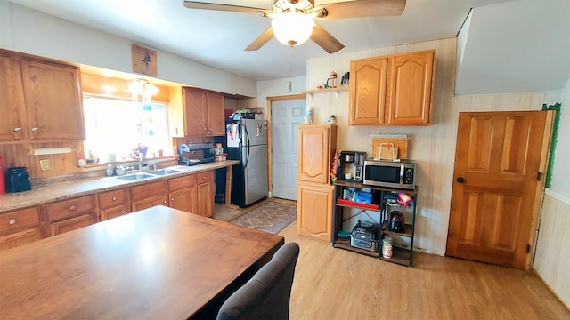 kitchen with ceiling fan, appliances with stainless steel finishes, sink, and light wood-type flooring