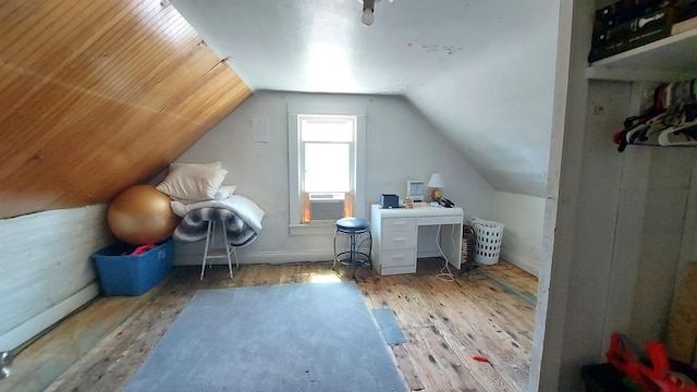 additional living space with cooling unit, lofted ceiling, and hardwood / wood-style floors