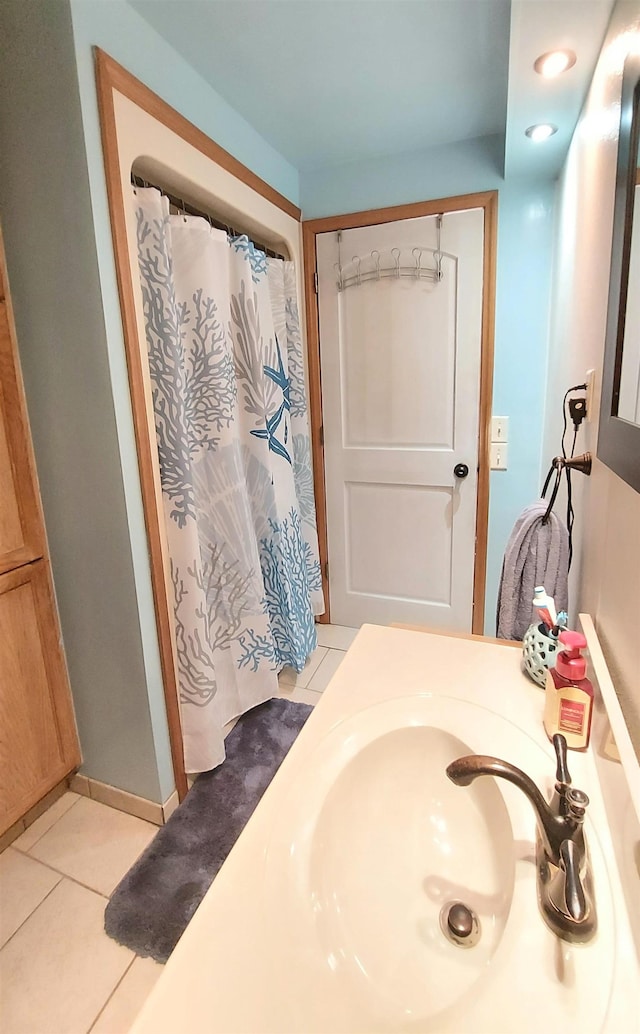 bathroom with tile patterned flooring, sink, and curtained shower