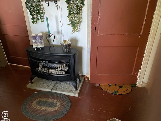 details with a wood stove and hardwood / wood-style flooring