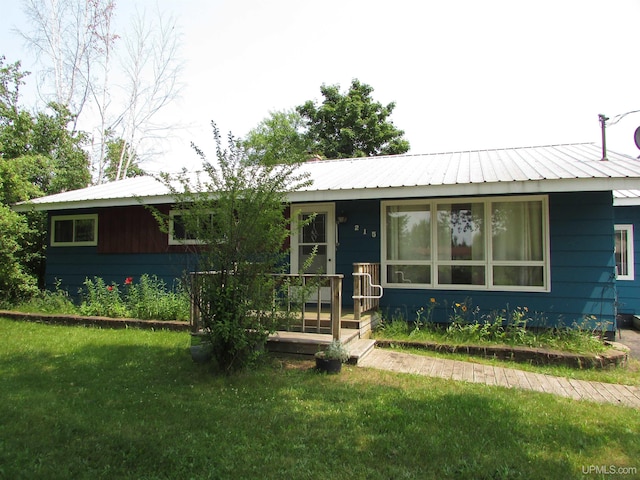 ranch-style house with a front lawn and metal roof