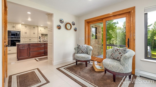 interior space with baseboard heating, light tile patterned floors, and plenty of natural light