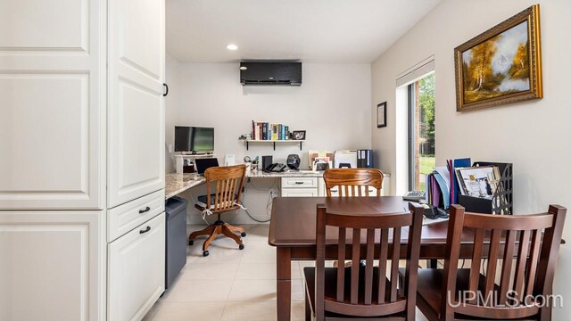 dining area with a wall mounted AC, light tile patterned floors, and built in desk