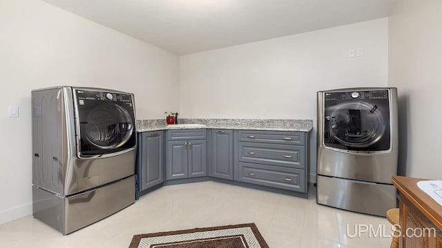 laundry room featuring cabinets, washer / dryer, and light tile patterned floors