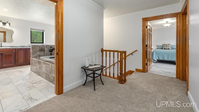 hall with crown molding, sink, and light tile patterned floors