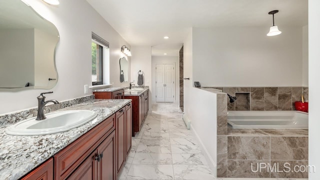 bathroom featuring dual vanity, tiled bath, and tile patterned floors