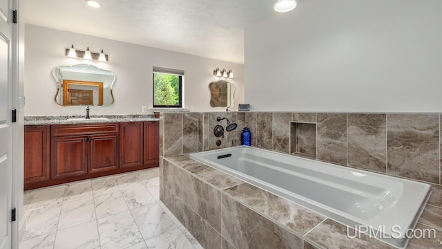 bathroom with vanity, tiled tub, and tile patterned floors