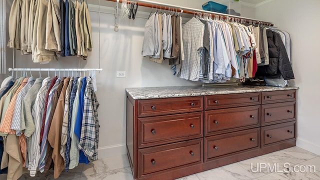 walk in closet with light tile patterned floors