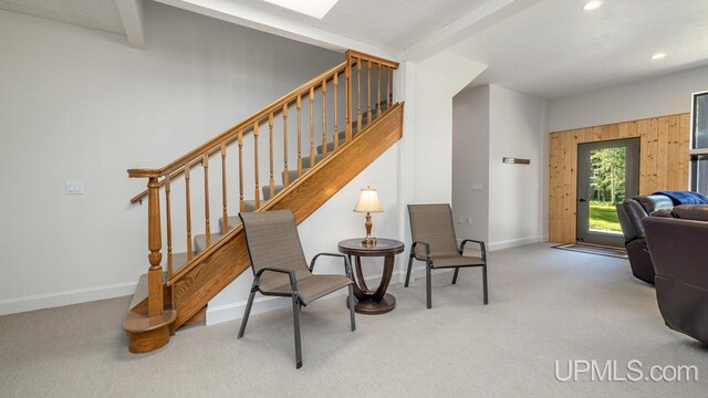 sitting room with beamed ceiling and carpet