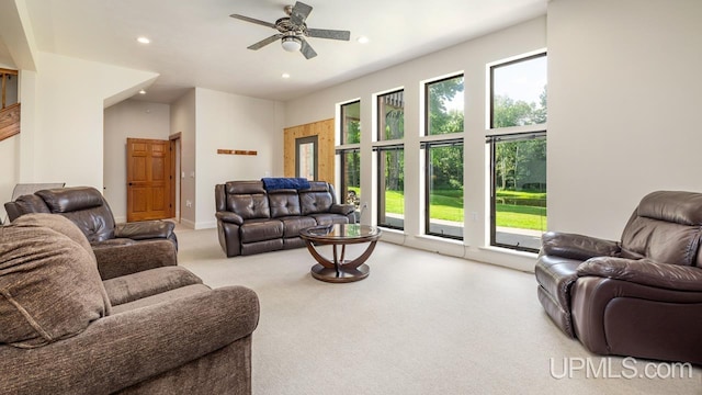 living room with light carpet, ceiling fan, and a healthy amount of sunlight