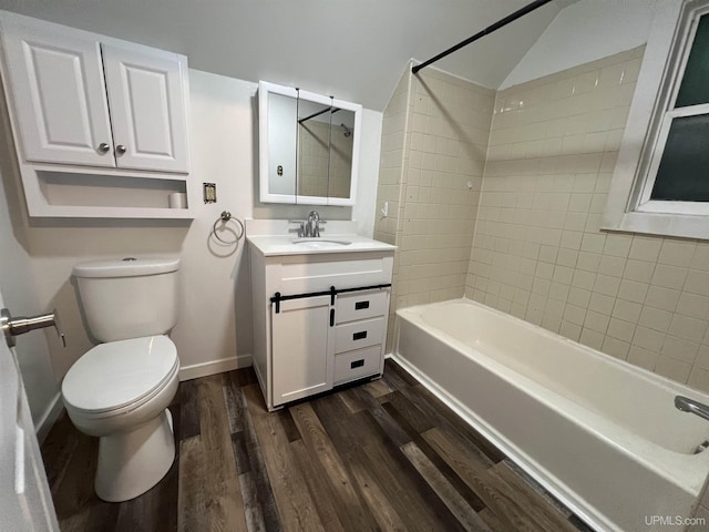 full bathroom featuring lofted ceiling, toilet, wood-type flooring, vanity, and tiled shower / bath combo