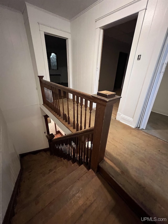 staircase featuring wood-type flooring and crown molding