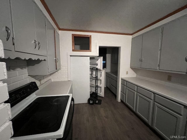 kitchen featuring gray cabinetry, crown molding, dark hardwood / wood-style flooring, electric stove, and decorative backsplash