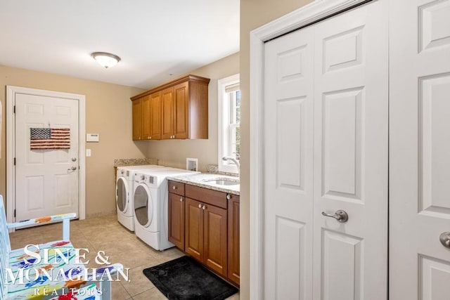 washroom featuring light tile patterned flooring, cabinets, washer and dryer, and sink