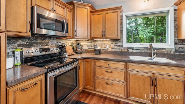 kitchen featuring dark hardwood / wood-style flooring, sink, decorative backsplash, and stainless steel appliances