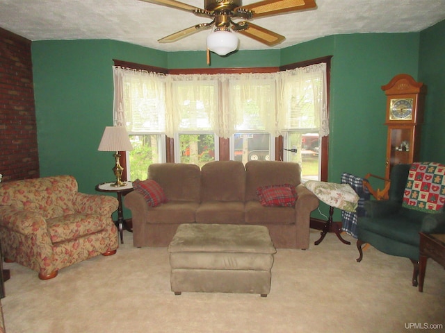 living room with brick wall, carpet floors, and ceiling fan