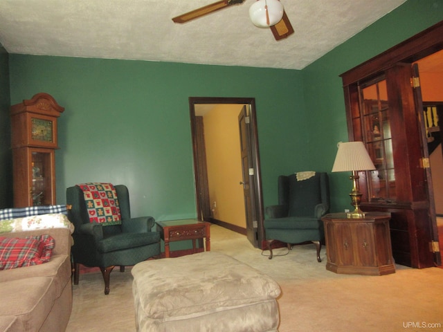 living room with light carpet, a textured ceiling, and ceiling fan