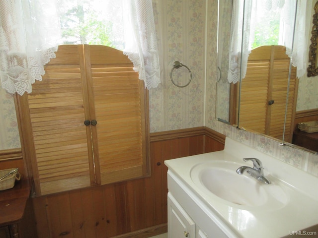 bathroom featuring vanity and wooden walls