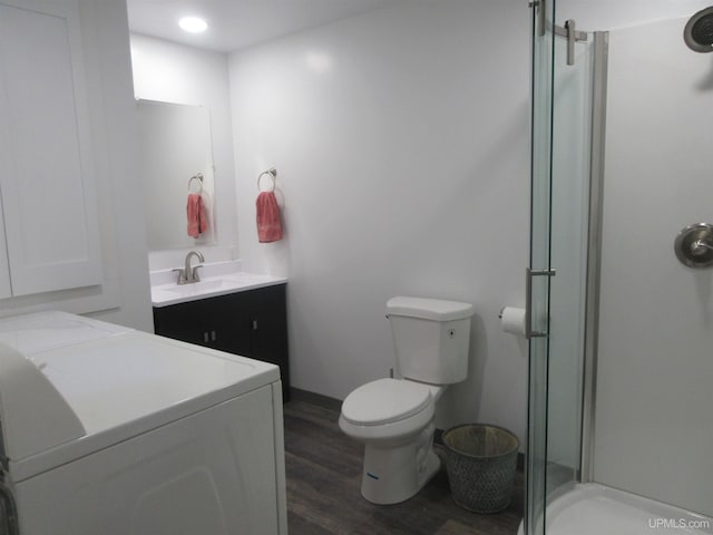 bathroom featuring washer / dryer, vanity, toilet, and hardwood / wood-style floors