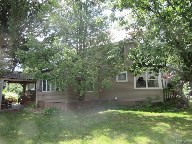 view of home's exterior featuring a gazebo and a lawn