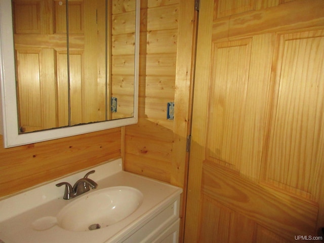 bathroom featuring vanity and wooden walls