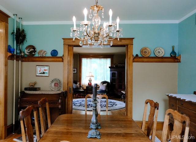 dining area featuring crown molding, hardwood / wood-style floors, and a notable chandelier