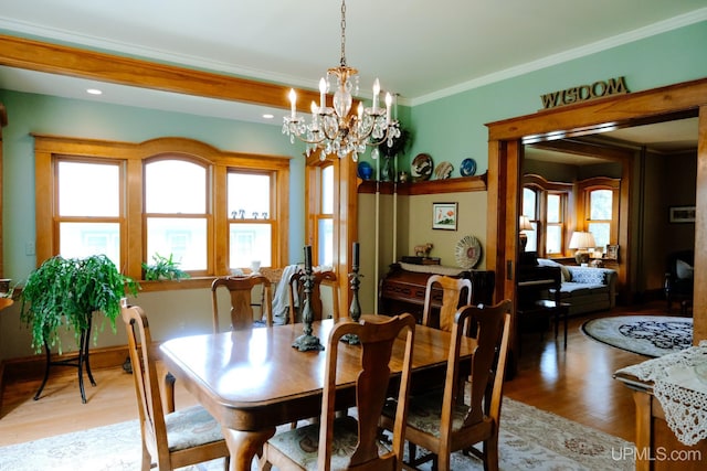 dining area featuring crown molding, a chandelier, and light hardwood / wood-style floors