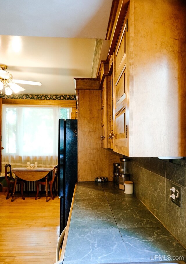 kitchen with ceiling fan and black fridge