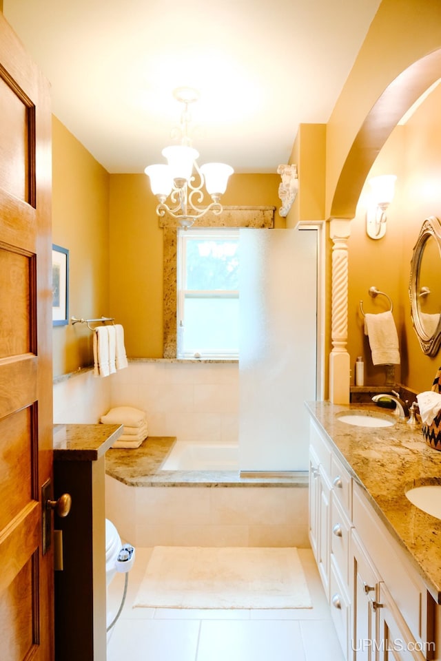 bathroom featuring vanity, a notable chandelier, tile patterned floors, and a bathing tub