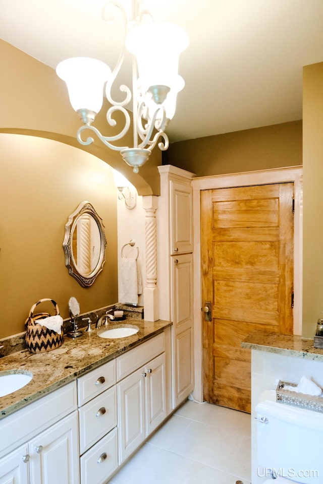 bathroom with a notable chandelier, vanity, and tile patterned floors