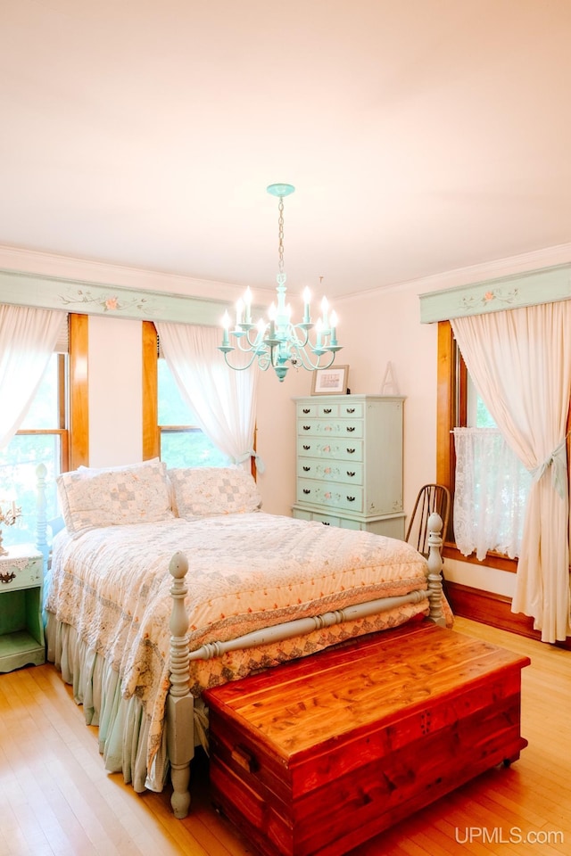 bedroom featuring a notable chandelier and light wood-type flooring