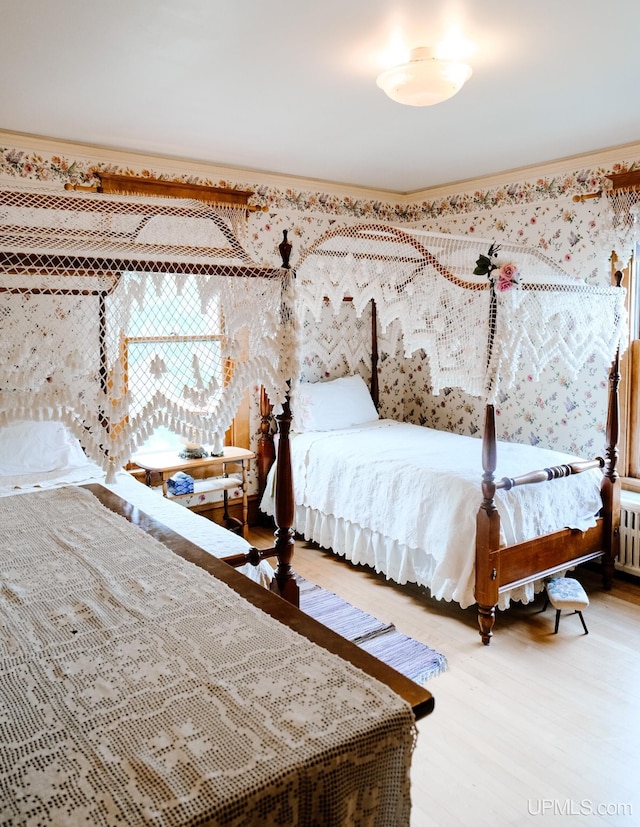 bedroom with crown molding and hardwood / wood-style flooring