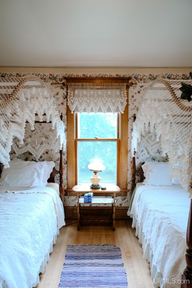 bedroom featuring crown molding and light hardwood / wood-style flooring