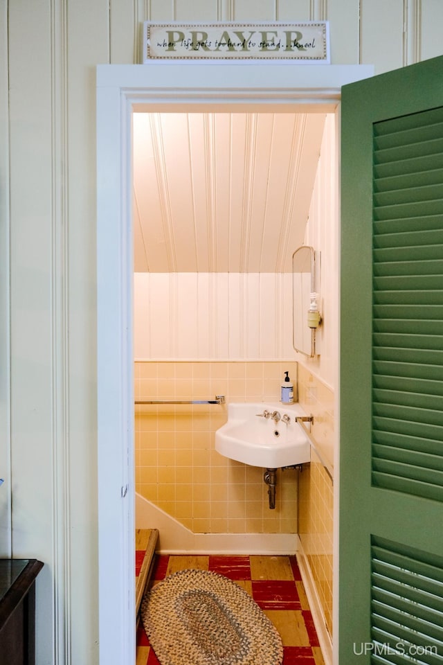 bathroom featuring tile walls and sink