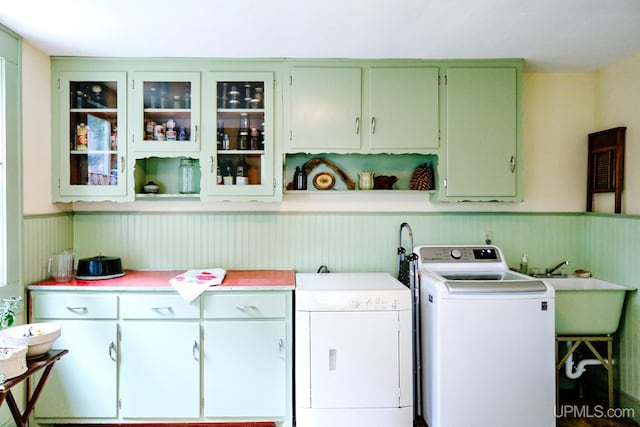 laundry room featuring cabinets, sink, and wood walls