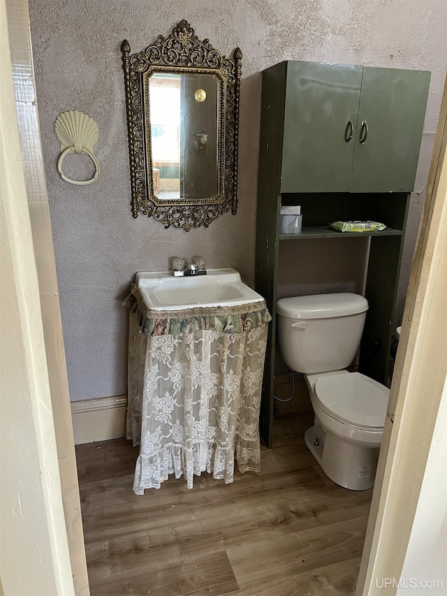 501 E N St, Ishpeming, MI 49849 - bathroom featuring wood finished floors, toilet, a textured wall, a sink, and baseboards