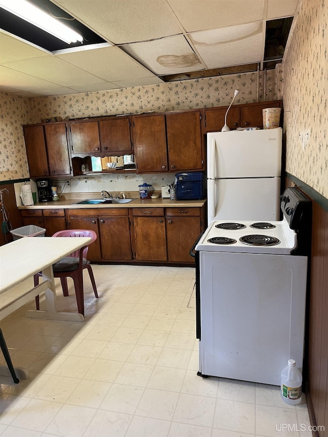 501 E N St, Ishpeming, MI 49849 - kitchen with wallpapered walls, white appliances, wainscoting, a sink, and light countertops