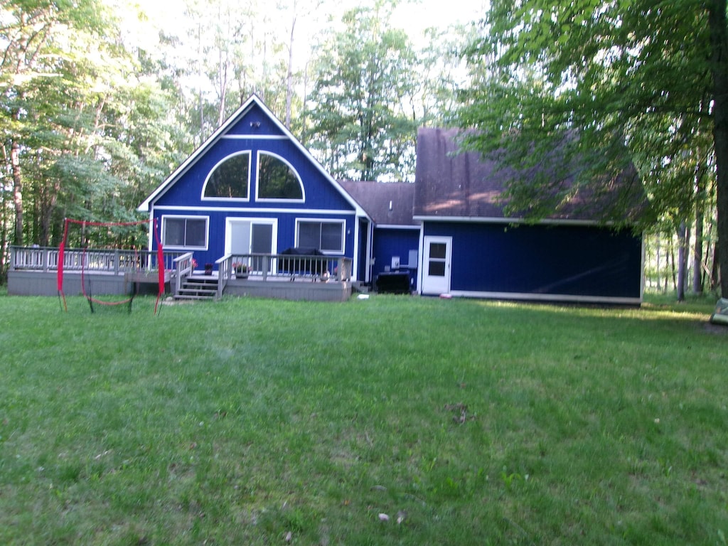 rear view of property with a yard and a deck