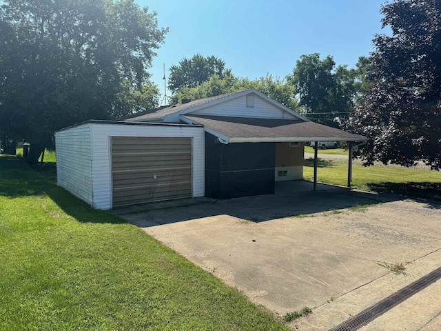 garage with a carport and a yard