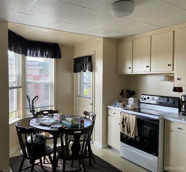 kitchen featuring range with electric stovetop, a paneled ceiling, and cream cabinetry