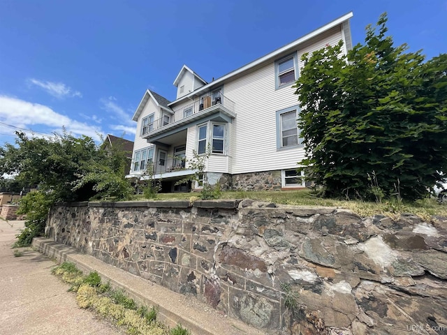 view of side of home featuring a balcony