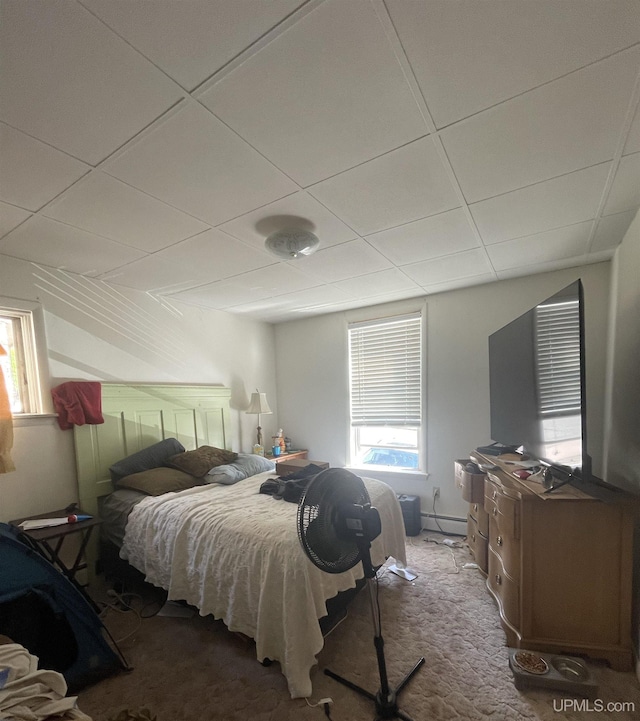 carpeted bedroom with a drop ceiling and baseboard heating