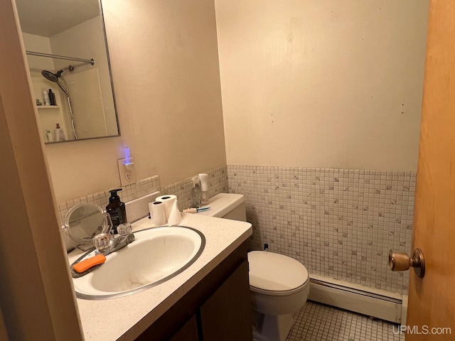 bathroom with tile walls, vanity, a baseboard heating unit, toilet, and tile patterned floors