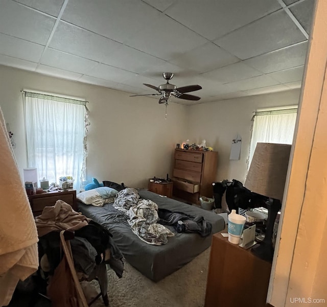 bedroom with carpet flooring, a paneled ceiling, and ceiling fan