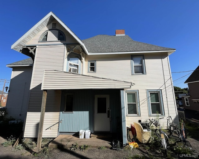 rear view of house featuring covered porch