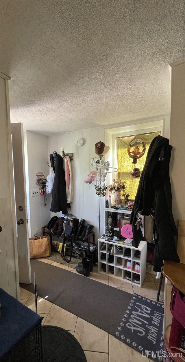 mudroom with light tile patterned floors and a textured ceiling