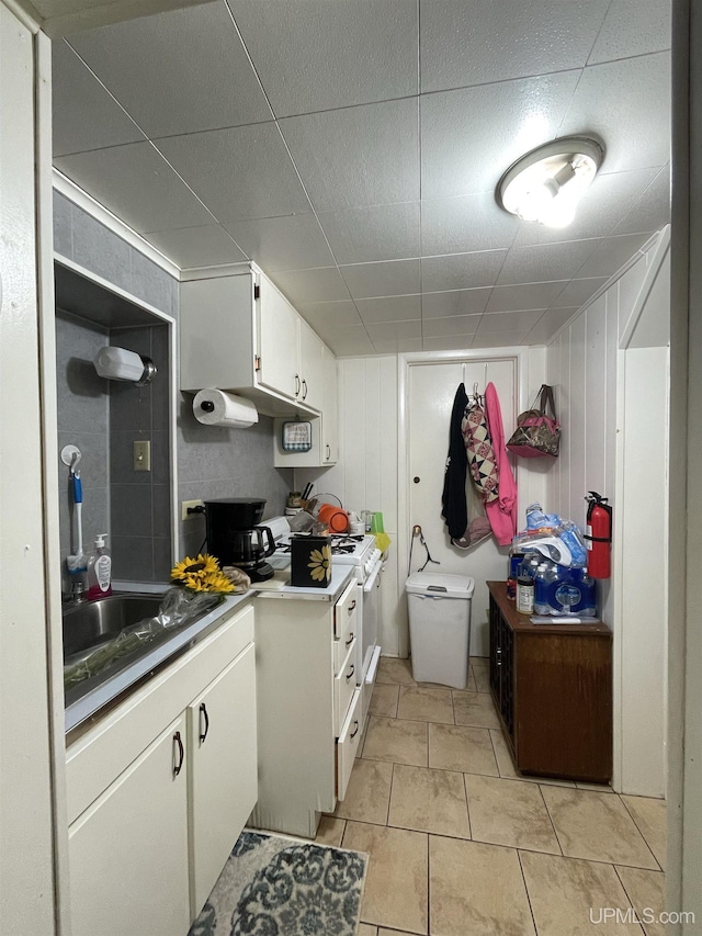 kitchen featuring light tile patterned flooring, sink, and white cabinets