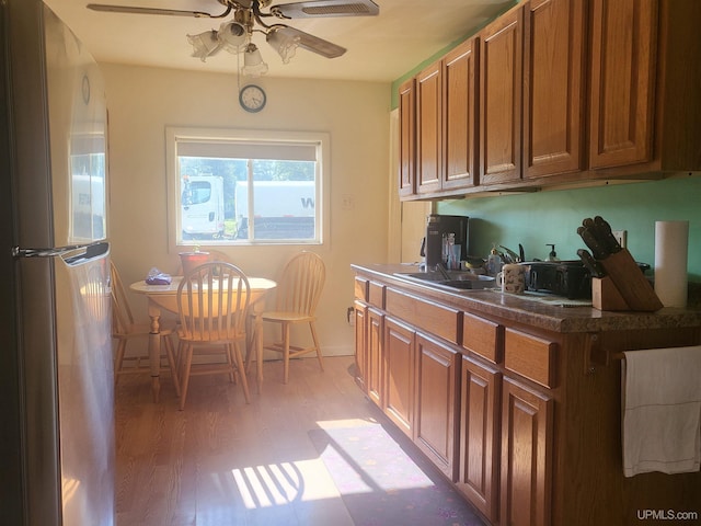 kitchen with light hardwood / wood-style flooring, stainless steel refrigerator, sink, and ceiling fan