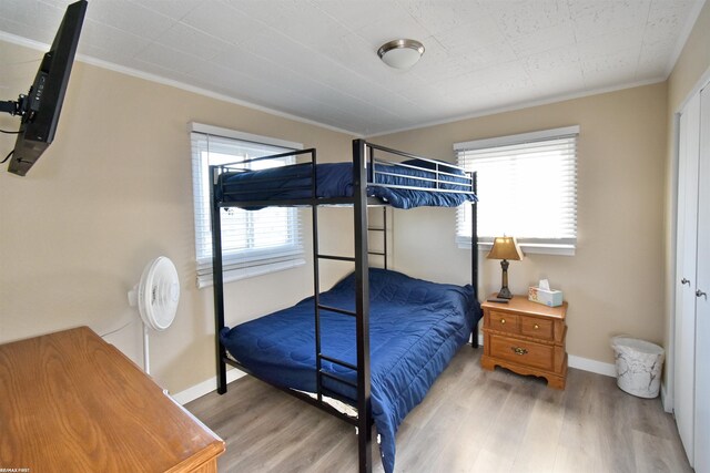 bedroom featuring light hardwood / wood-style flooring and crown molding