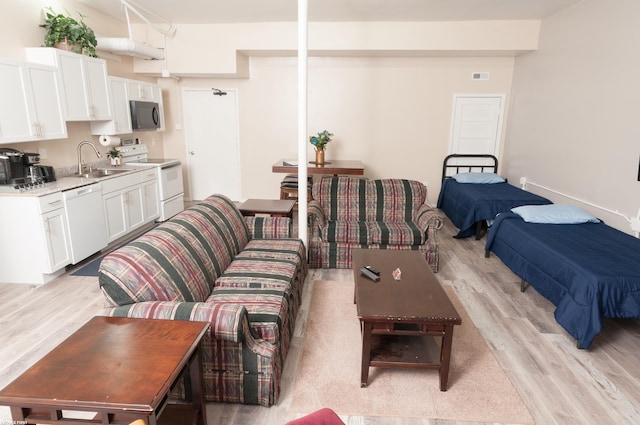 living room with light wood-type flooring and sink